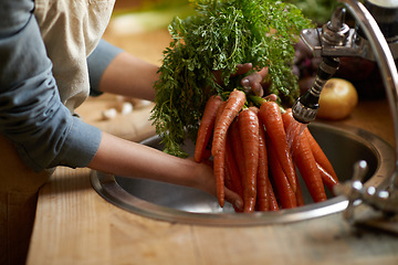 Image showing Person, carrots and washing in sink as vegetable nutrition for wellness ingredient for healthy, salad or organic. Hands, water and clean in kitchen for meal preparation with recipe, vitamins or fibre