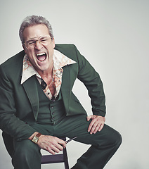 Image showing Retro, fashion and mature man shouting in studio with mockup space, groovy suit and pipe. Funky clothes, screaming and person with vintage style on chair, unique and excited on white background.