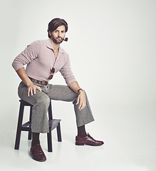 Image showing Vintage, man and portrait or pipe in studio with retro fashion, hipster outfit and confidence on chair. Model, person and face with 70s style, mock up space and sunglasses with white background