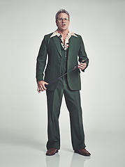 Image showing Mature, man and serious with fashion in studio, suit and grey background with riding crop. Tuxedo, elegance and retro with unique style and formal in expensive clothes, classy and fashionable