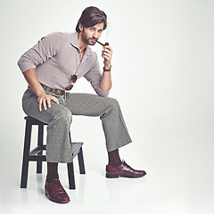 Image showing Vintage, man and portrait or smoking in studio with retro fashion, hipster outfit and confidence on chair. Model, person and face with 70s style, mock up space and calm expression on white background