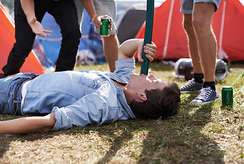 Image showing Alcohol, drinking and funnel with man at festival, on ground for event, party or social gathering. Beer, grass and young drunk person with friends on grass or field outdoor at camp for celebration