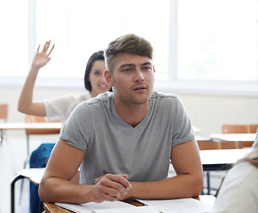 Image showing Man, learning and thinking in classroom at desk for education, knowledge and development at university. Male student, college and wonder in lecture for ideas, study and sitting on seat at campus