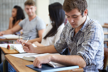 Image showing University, book and man in class reading with ambition for development in learning, opportunity and future. Education, knowledge and growth for college student in lecture, studying for exam or test.