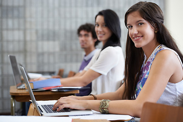 Image showing University, laptop and portrait of woman in classroom typing with smile, learning and future opportunity. Education, knowledge and growth for group of students in college lecture studying for exam.