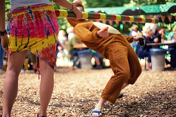 Image showing Limbo, game and person at party outdoor with balance and playing at a music festival, event or challenge. Fun, people and outdoor in woods, forest or person in social activity at party in bear suit