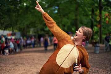 Image showing Halloween, costume and man with beer to drink at happy celebration outdoor in bear outfit. Animal, suit and person pointing to trees with lager, bottle and drinking alcohol in park at festival