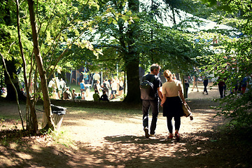 Image showing Love, couple and holding hands at music festival outdoor, carnival and celebrate valentines day date. Back view, man and woman together at party, park or walk in nature for support in relationship