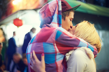 Image showing Couple, hug and kiss with love at music festival for bonding, affection or celebration together. Happy, woman and man with cap at colourful event for enjoyment, adventure or experience together