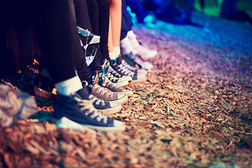 Image showing Group, feet and party at music festival in woods, relax and youth in trendy fashion at event. People, line and spotlight in sneakers at concert and social culture in forest for celebration in crowd
