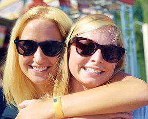 Image showing Portrait, concert and women with sunglasses, hug and smile with happiness or music festival. Face, people or outdoor with friends or eyewear with weekend break or excited with embrace with summer fun