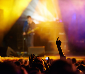 Image showing Concert, audience and hands in crowd with band for music festival, night club and dancing with light. Disco, party and people with signs, gesture or performance at rock event with stage entertainment