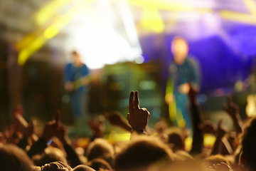 Image showing Concert, audience and hand or sign with band for music festival, night club and cheering with energy. Disco, party and people with light, gesture and performance at rock event with entertainment