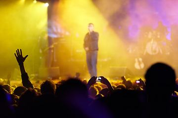 Image showing Concert, audience and hands in crowd with band for music festival, night club and cheering with light. Disco, artist and people with sign, gesture and performance at rock event with entertainment