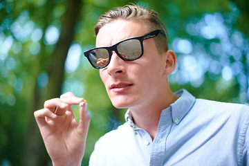 Image showing Sunglasses, man and smoking weed outdoor at event, celebration and music festival alone. Cigarette, marijuana and face of young person at party, carnival and concert in nature with cannabis joint