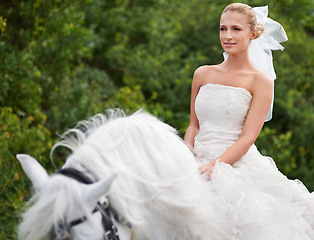 Image showing Bride, woman and riding with horse outdoor or happiness for celebration, marriage and confidence in countryside. Wedding, person and stallion on lawn in field with smile, dress and animal at ceremony