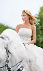 Image showing Wedding, woman and riding with horse outdoor on grass for celebration, marriage or confidence in countryside. Bride, person and stallion in field with smile, dress and animal at ceremony in nature
