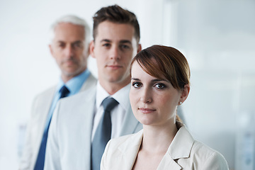 Image showing Portrait of three corporate business people , standing in a row and in broad room. Smiling friendly group of three business partners of different age private company staff posing for office