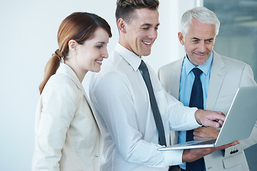 Image showing Business people, laptop and discussion on idea in office, communication and meeting in workplace. Coworkers, collaboration and happy with research on internet, planning and teamwork on technology