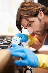 Image showing Man, kitchen and serious in cleaning a countertop with cloth, spring clean and polishing for hygiene at home. Stove, responsibility and routine to remove dirty stains, germs with water and soap