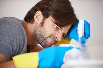 Image showing Man, face and spraying surface for housekeeping, hygiene or disinfection on furniture or table at home. Male person, maid or cleaner checking dirty spots for wiping, bacteria or germ removal at house