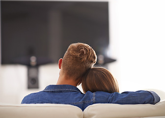 Image showing Couple, together and hug watching TV, home and relaxing for break, couch or sofa while bonding. Partners, streaming and enjoyment of subscription, relax and embrace in lounge for romance and love