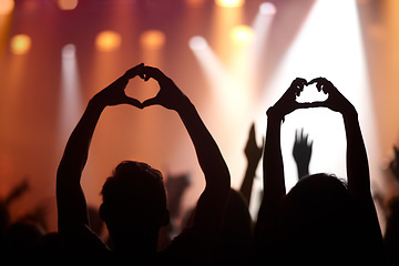 Image showing Music lovers. Heart hands, love and silhouette at music festival, kindness and peace emoji or symbol at concert. People, audience and back of crowd at party or event,.