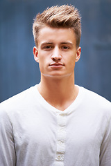 Image showing Portrait, serious and young man with style on a wall background in the city. Relax, face and caucasian male person in a casual tshirt with trendy, cool fashion from New Zealand with confidence