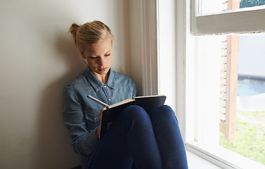 Image showing Woman, window and writing ideas in notebook, planning and brainstorming or reminder for schedule at home. Female person, information and journal for inspiration, author and notes in diary for project