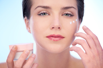 Image showing Portrait of woman, application or face cream for skincare, beauty or cosmetics on blue background. Antiaging, studio or model with product, creme or glow for lotion, dermatology or facial treatment