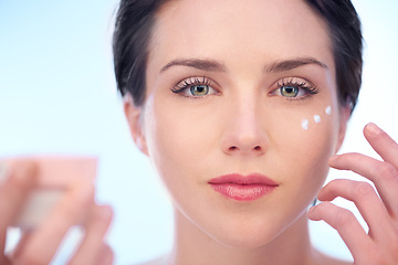 Image showing Portrait of woman, wellness or face cream for skincare, beauty or cosmetics on blue background. Antiaging, studio or model with product application or glow for lotion, dermatology or facial treatment