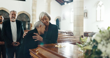 Image showing Senior women, hug and funeral in church for comfort, support and care with crying, sad and religion. Family, friends and embrace for death, loss and console with love, empathy and faith by coffin