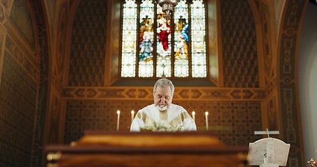 Image showing Funeral, church and priest with prayer by coffin for memorial service, sermon and ceremony for death. Religion, guidance and male pastor praying with congregation for comfort with casket in chape