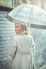 Image showing Woman, umbrella and walking with rain in city, thinking or ideas with cover, weather and memory in winter. Person, outdoor and road with travel, journey or commute with water on sidewalk in Cape Town