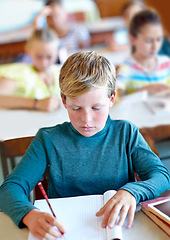 Image showing Student, boy and writing notes for learning in classroom, book and problem solving at school. Male person, child and study information for exam prep in notebook, solution and journal for assessment