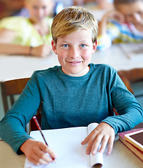 Image showing Student, portrait and boy writing notes for learning in classroom, book and problem solving at school. Male person, child and information for exam prep in notebook, solution and journal for test