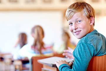 Image showing Child, portrait and school desk with notebook for education in teaching lesson or knowledge, development or scholarship. Boy, face and smile or writing in classroom for project, learning or studying