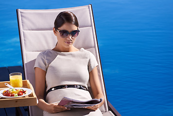 Image showing Woman, reading and magazine on sunbed outdoor with sunglasses for relax, snacks and lifestyle news. Person, publication and paper by pool on holiday, vacation and summer trip at hotel or mockup space