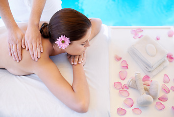 Image showing Flowers, massage and woman at spa pool for health, wellness and luxury holistic treatment. Self care, peace and girl on table with masseuse for body therapy, relax and calm hotel service with petals