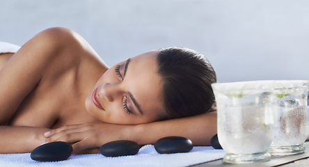 Image showing Sleeping, hot stone or woman in spa with beauty or flower for wellness, treatment or hospitality. Relax, resort or healing therapy for happy person, client or masseuse in hotel on holiday vacation