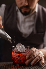 Image showing Bartender pouring cocktail at bar