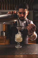 Image showing Expert bartender crafting a cocktail