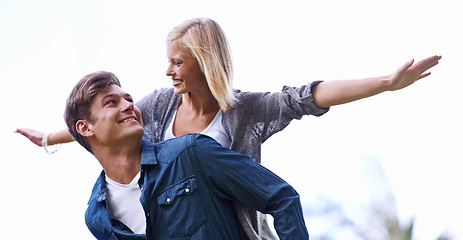 Image showing Couple, piggy back and plane with arms, smile or game by trees with care for connection with bonding outdoor. Man, woman and playful with airplane, wings or flight for freedom on journey for vacation