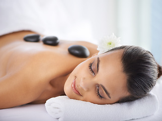 Image showing Calm, hot stone and woman with massage at spa for wellness, health and back treatment. Self care, cosmetic and young female person sleeping for warm stone back therapy at natural beauty salon.