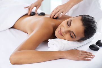 Image showing Relax, calm and woman with hot stone massage at spa for health, wellness and back treatment. Self care, sleeping and female person with warm rock skin therapy with masseuse at natural beauty salon.