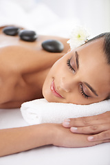 Image showing Sleeping, hot stone and woman with massage at spa for wellness, health and back treatment. Self care, cosmetic and young female person relaxing for warm stone back therapy at natural beauty salon.