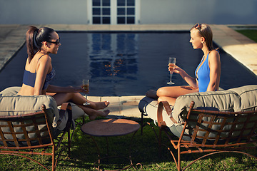 Image showing Women, friends and relax with wine by pool for holiday, vacation or summer adventure with sunglasses and smile. People, swimwear and happy with champagne in backyard or garden of hotel accommodation