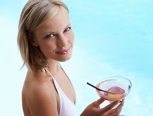Image showing Smile, portrait and woman at pool with cocktail, sunshine and travel for summer holiday at hotel. Relax, water and face of happy girl on luxury vacation with drink, weekend and swimming in high angle