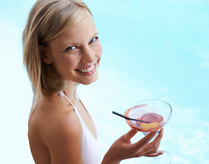 Image showing Smile, portrait and woman at swimming pool with cocktail, sunshine and travel for summer holiday at hotel. Relax, water and face of happy girl on luxury vacation with drink, weekend and high angle.