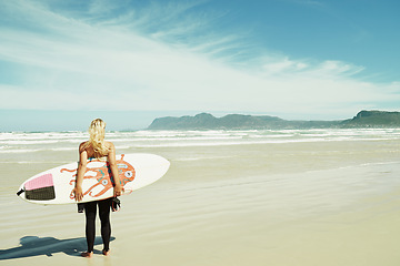 Image showing Beach, summer and woman with surfboard on space for travel, vacation or holiday on tropical coast. Fitness, sky and sand with surfer person outdoor in nature for exercise or training from back